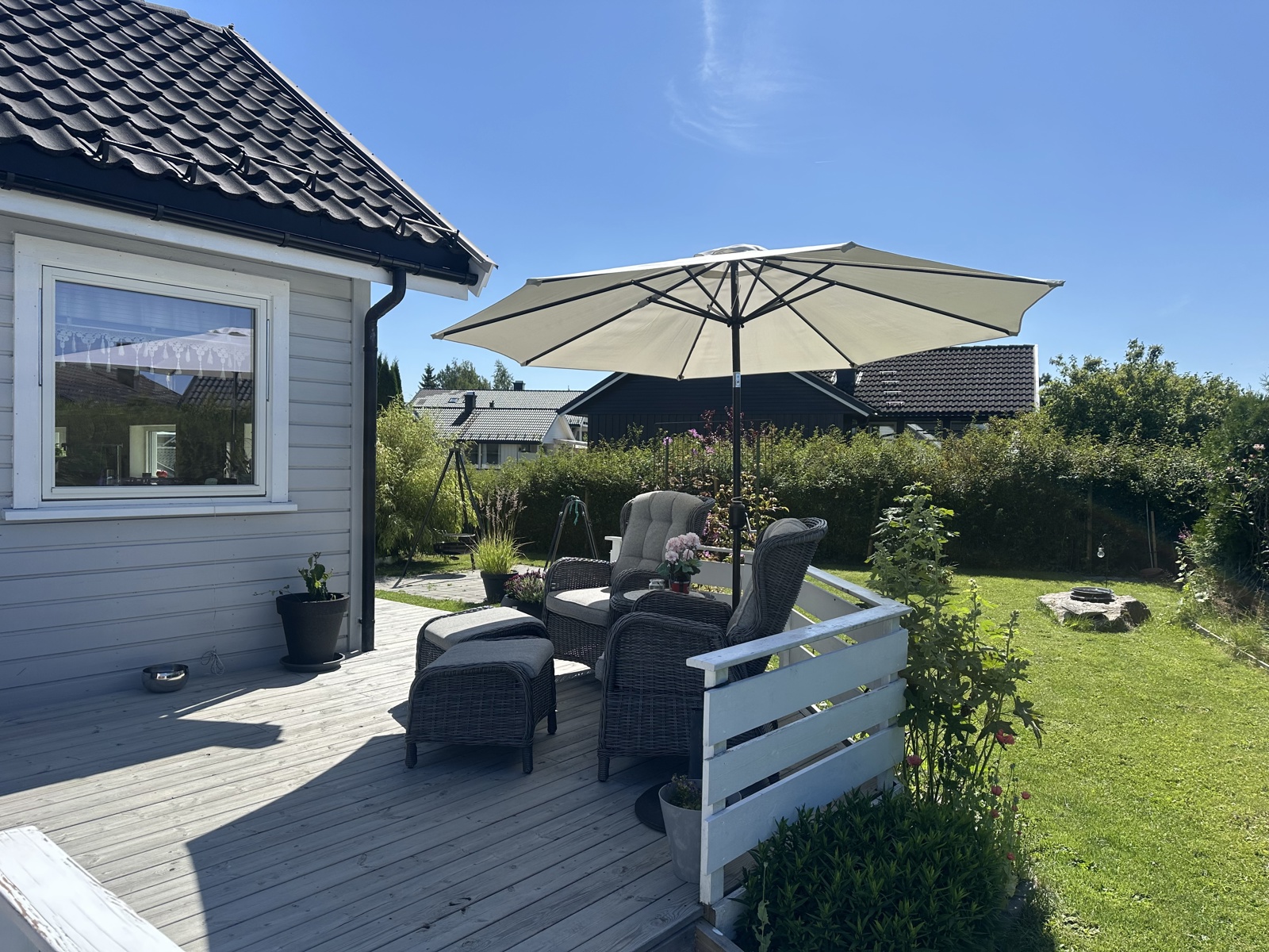 Lunt og fint i husveggen.Godt skjermet mot gaten av hekken. 