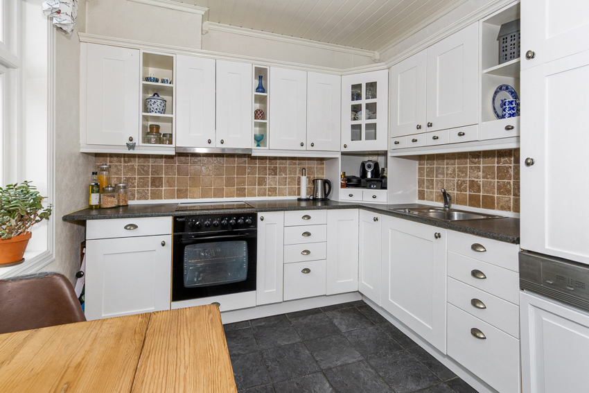 Nymalt hvit kjøkkeninnredning - godt med skap- og benkeplass