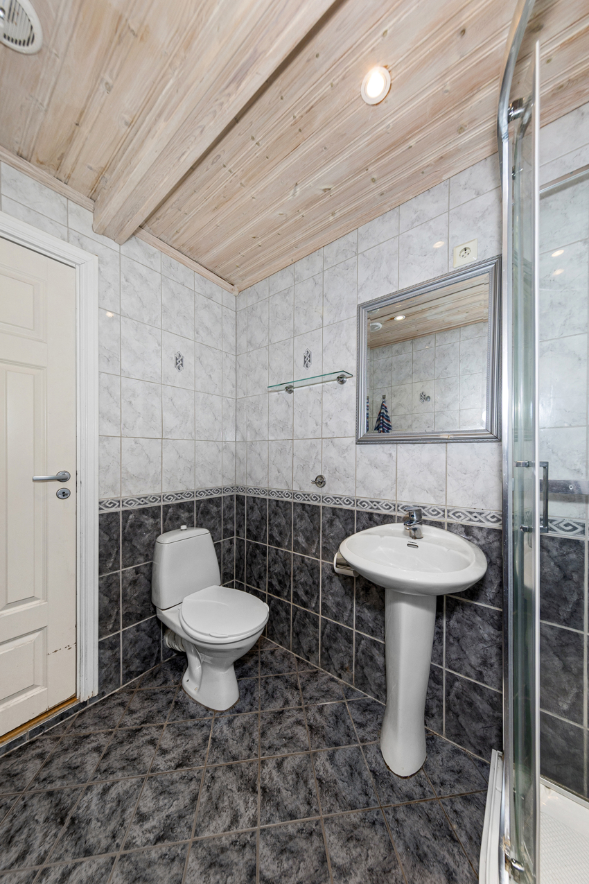 Badet har toalett, søyleservant og speil