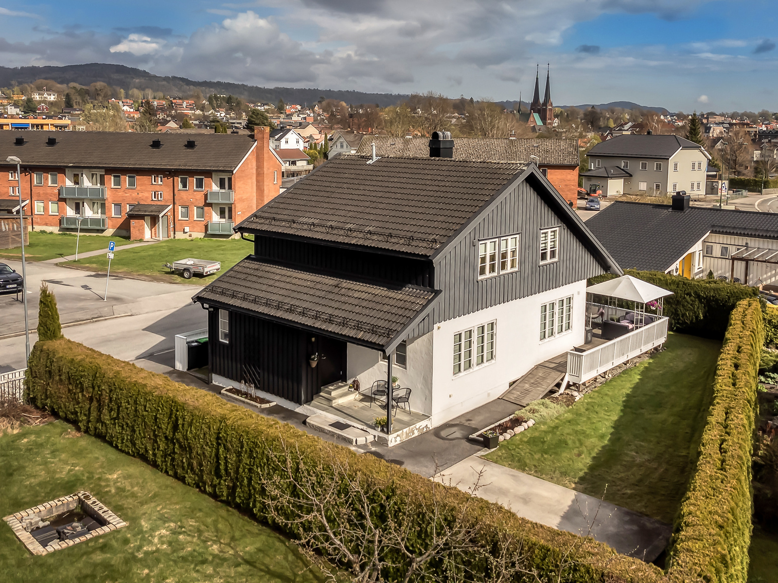 Tomten er pent opparbeidet med plen, asfaltert gårdsplass/innkjørsel og terrasse