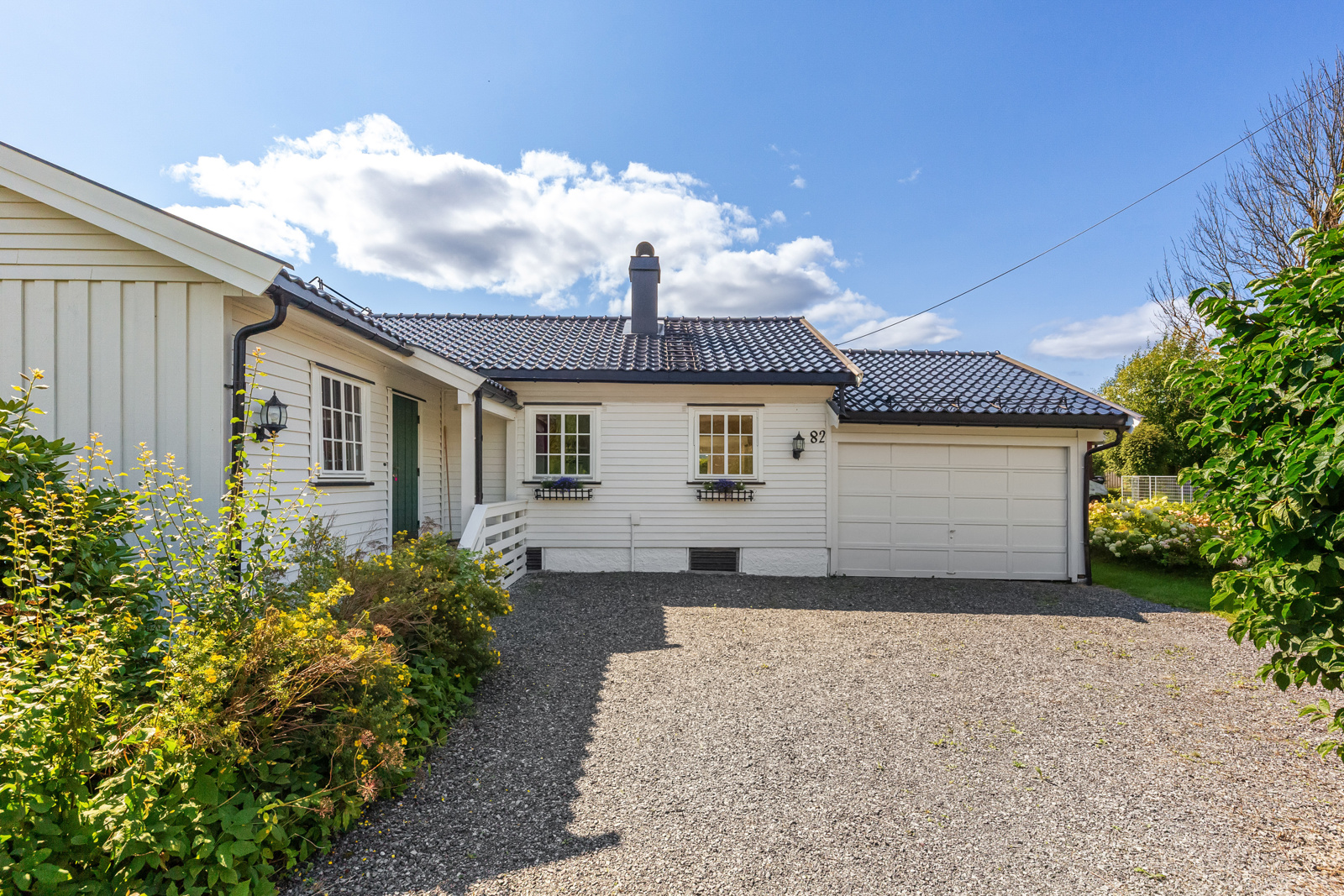 Lun gårdsplass. Garasjen er tegnet som carport og innkledning med vegg og port er ikke søkt godkjent i Skien kommune.