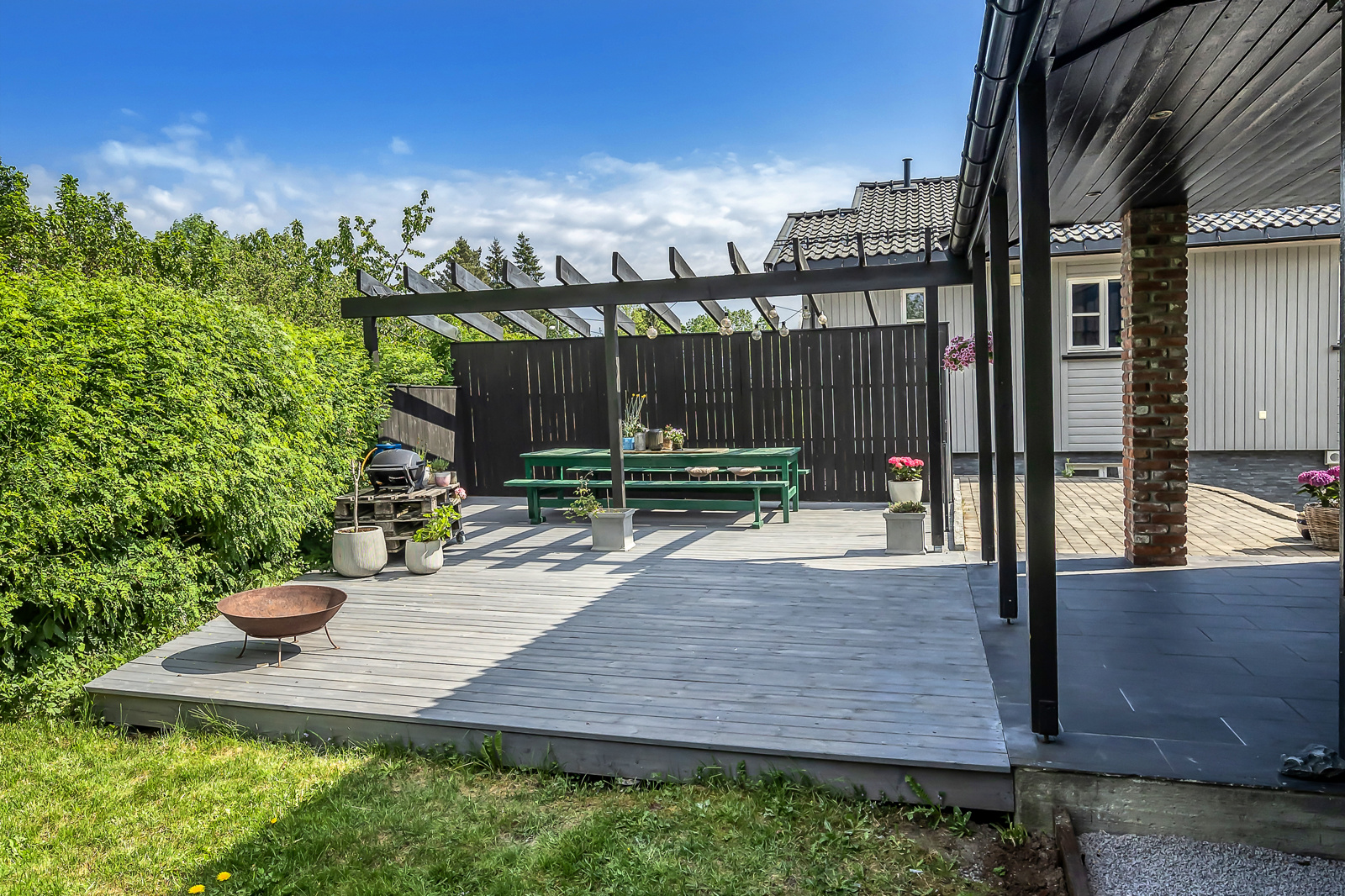 Et pent uteområde med Pergola og terrasse.