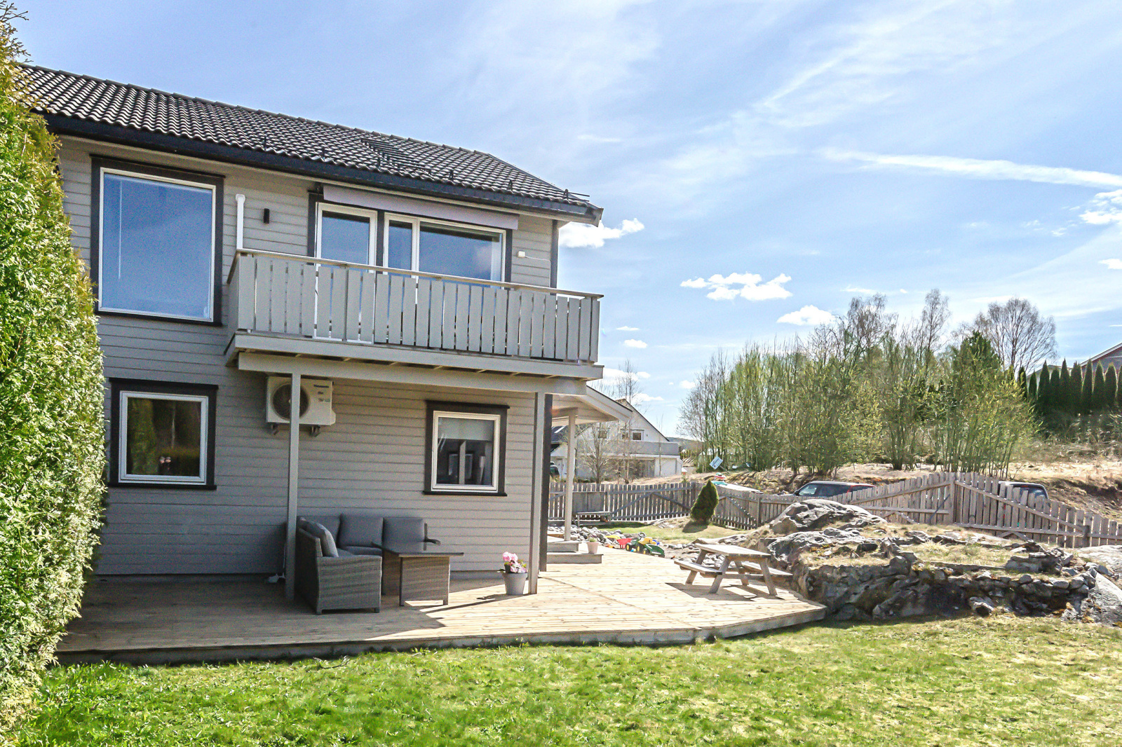 Hagen er inngjerdet og pent opparbeidet med plen, hekk og naturtomt.