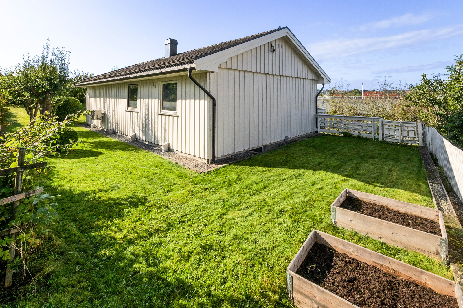 Fasadebilde - nordøst. Stor flat hage med muligheter for dyrking av egne grønnsaker og urter.