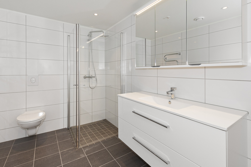 Ellers har badet en god innredning med helstøpt servant og benkeplate som gir lettere rengjøring. Dushjørnet har foldedører som gjør badet mer fleksibelt på størrelse. 