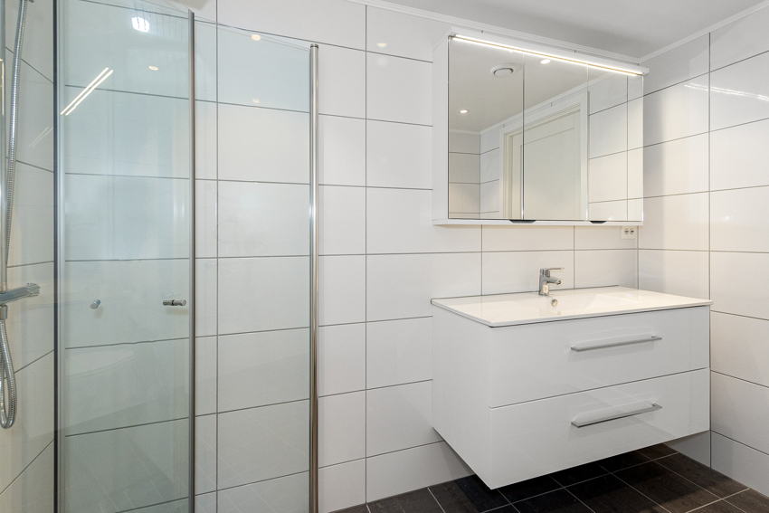 Ellers har badet en god innredning med helstøpt servant og benkeplate som gir lettere rengjøring. Dushjørnet har foldedører som gjør badet mer fleksibelt på størrelse. 