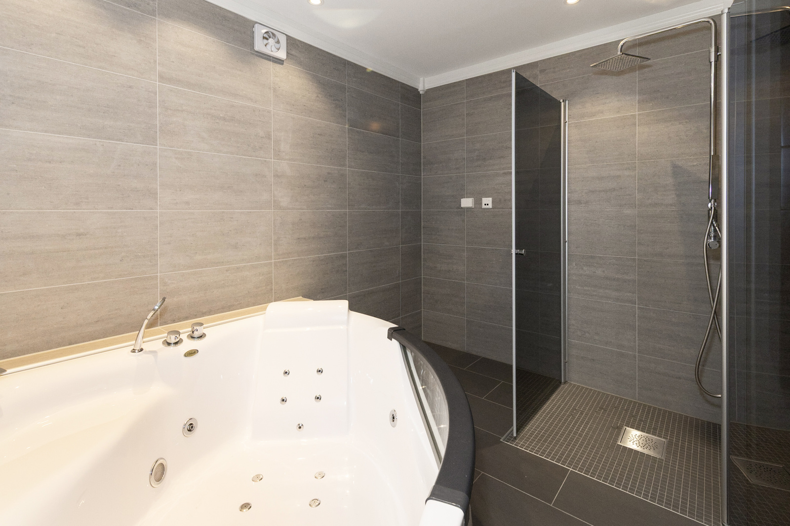 Badekar med god plass og integrerte massasjedyser, perfekt for avslapping etter en lang dag. Dusjnisjen er utstyrt med en regndusj og hånddusj.