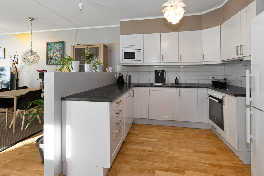 Kjøkkenet er lyst og romslig med pene overflater og god plass til spisebord.