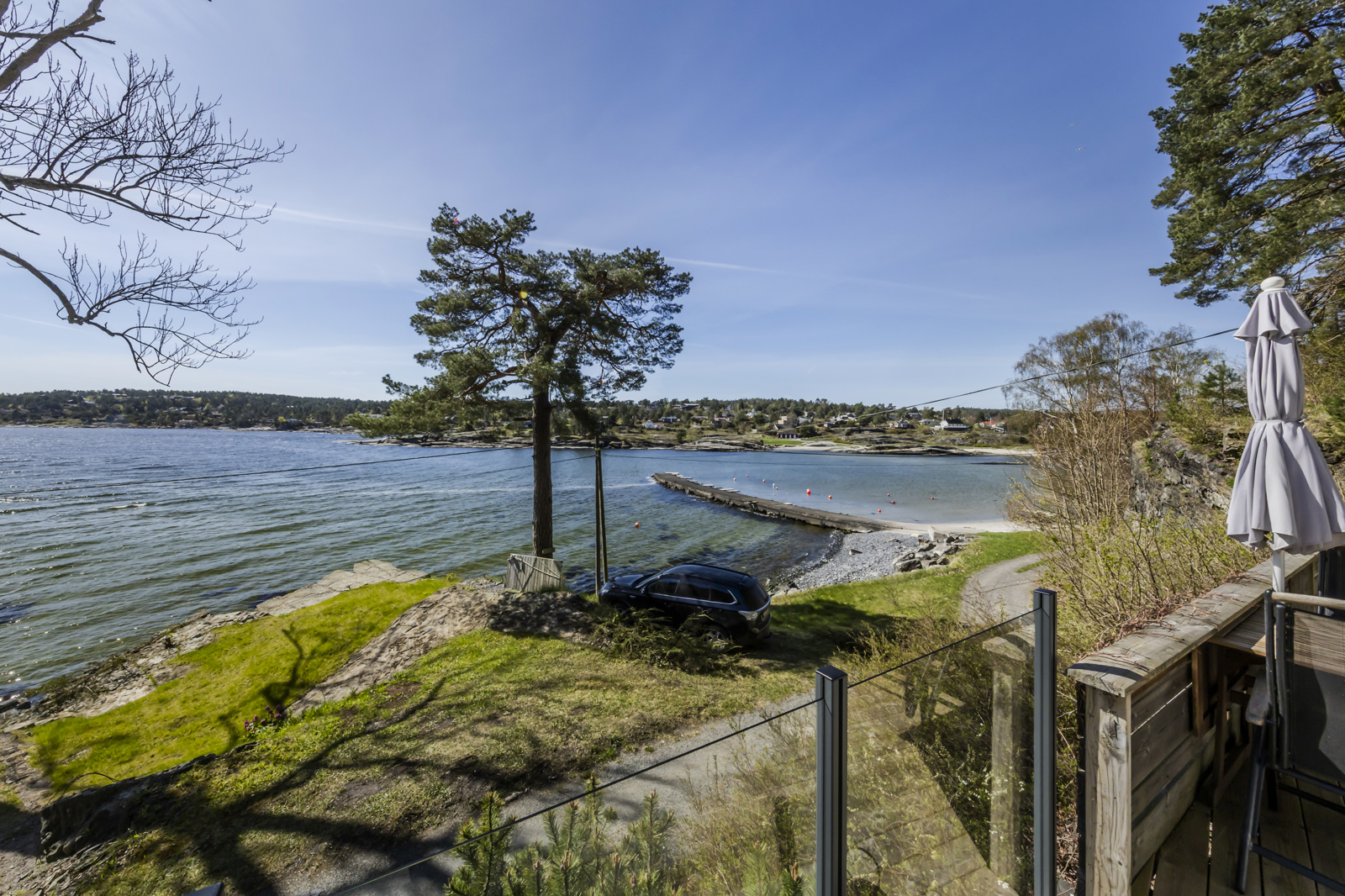 Ser man vestover, ser man hyttene på andre siden av fjorden, moloen og de idylliske sandstrendene innerst i vika