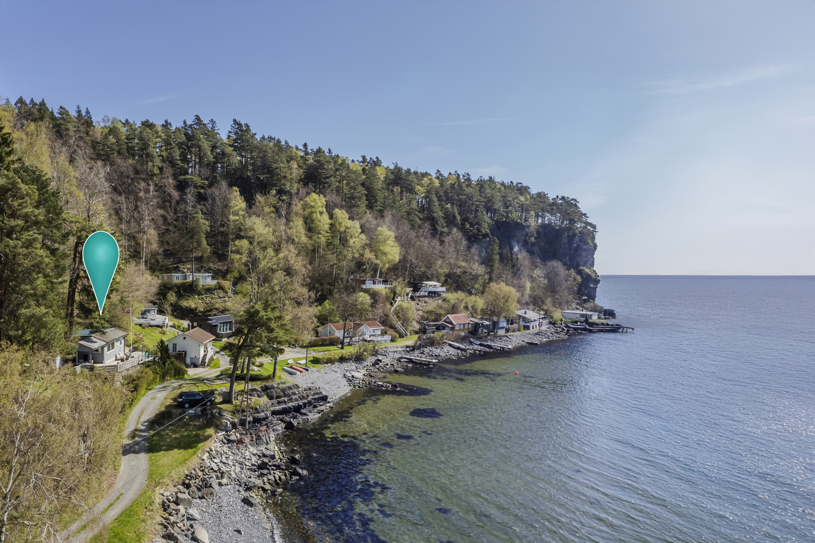 Spektakulær beliggenhet med høyt fjell i bakkant og fjorden og havet i forkant