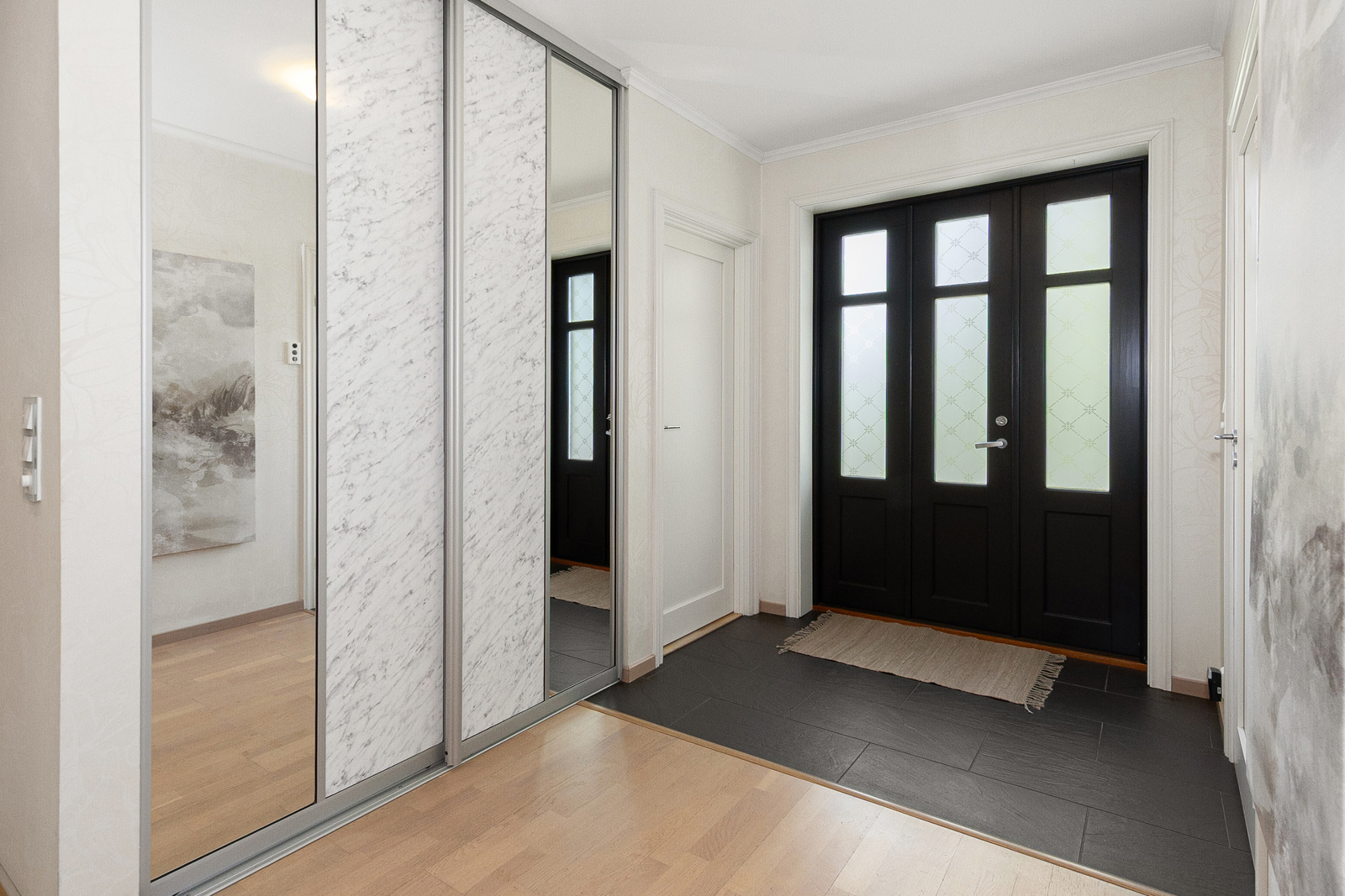 En romslig hall med skyvedørsgarderobe ønsker deg velkommen inn !