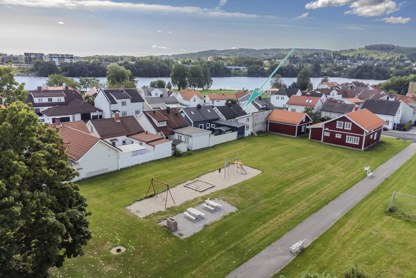 Oversiktsbilde over lekeplass og fotballøkke. Markering av huset med grønn pil.