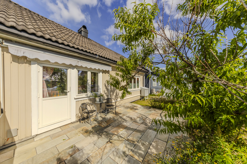 Steinbelagt uteplass på fremsiden av huset.