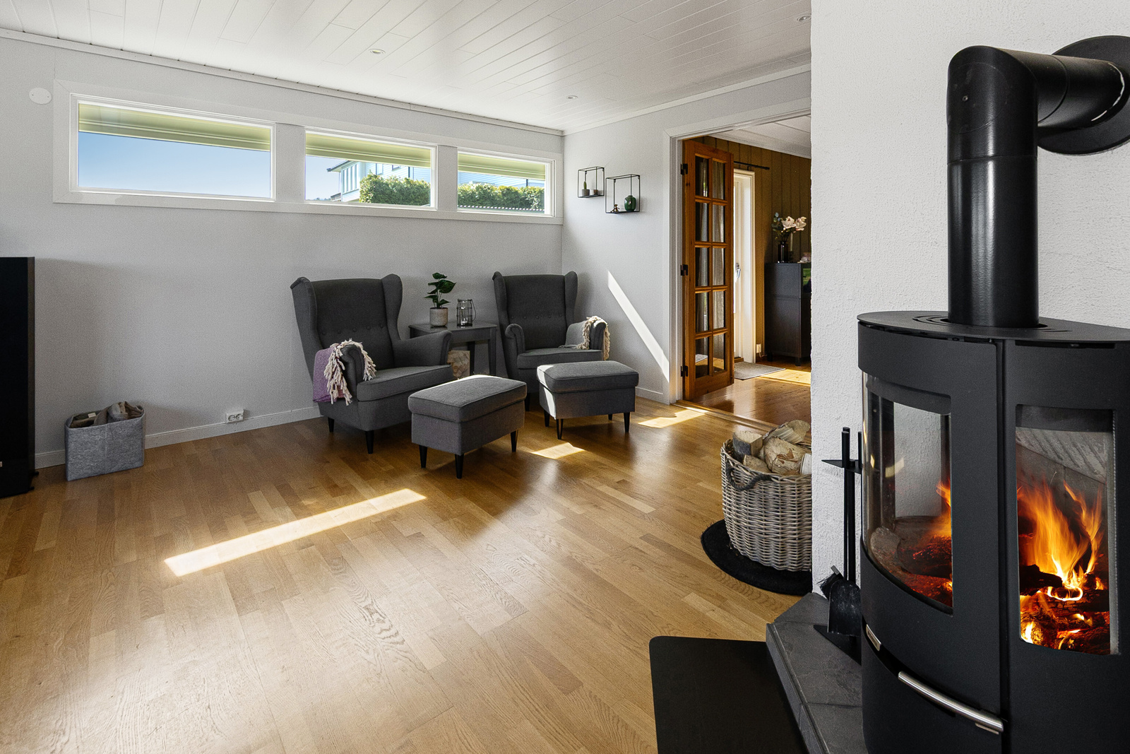 Romslig stue med vedovn og utgang til vestvendt terrasse.