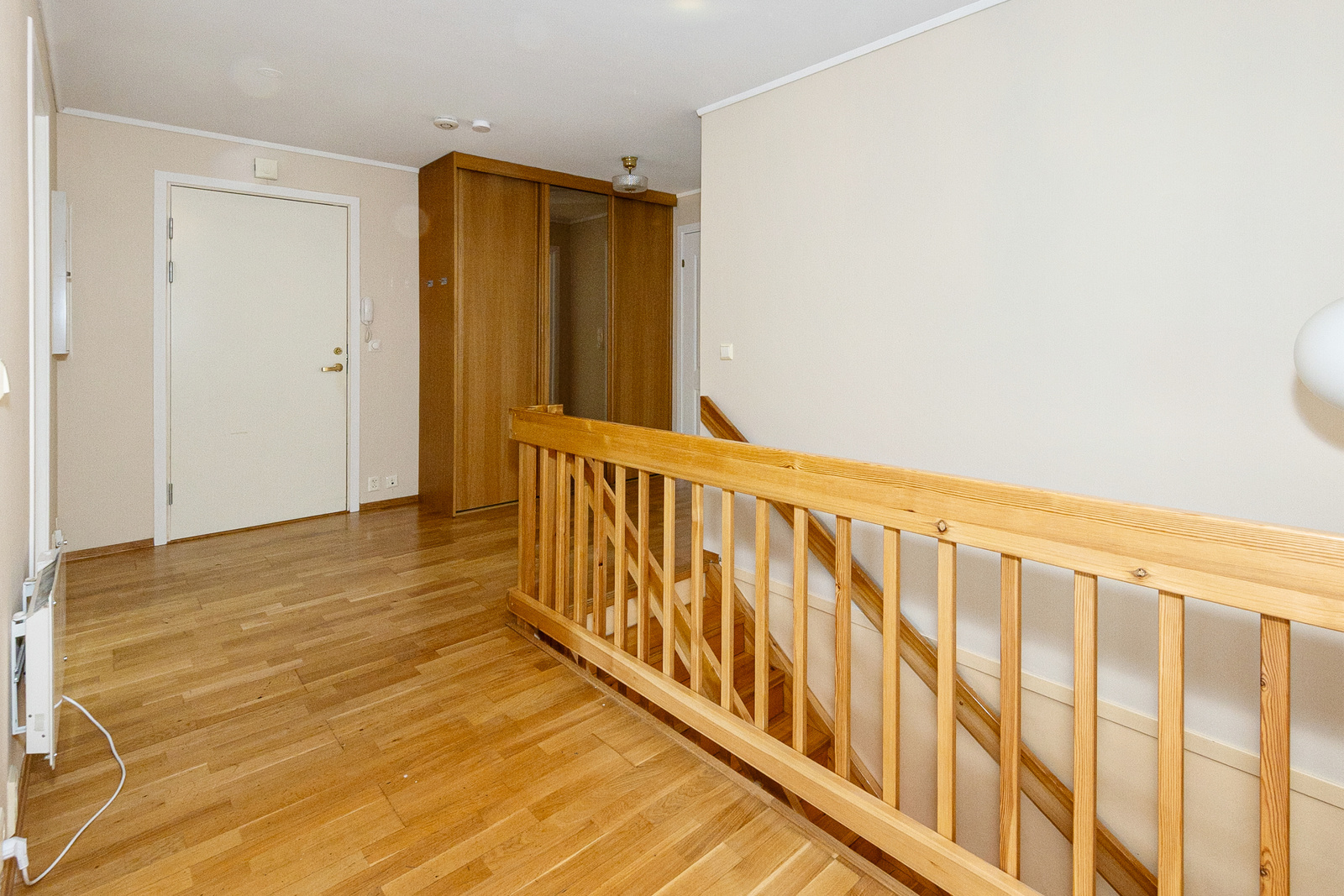 En romslig entre med skyvedørsgarderobe. Trapp til kjelleretasjen