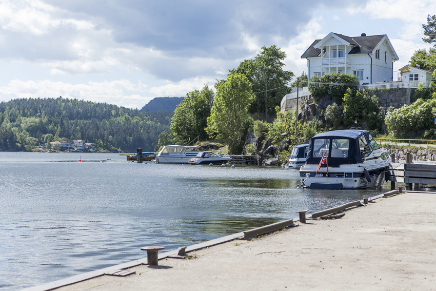 Bildet er fra Løveid. Et område nært Løveid sluser og den aktuelle tomten. Et lite idyllisk lite småsted med brygger og en liten badestrand.