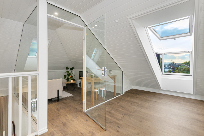 Loftstue med kontoret med glassvegger i bakgrunn. Megler opplyser om at kontoret og soverommene i loftsetasje ikke er godkjent for varig opphold og ikke godkjent/ bruksendret hos kommunen.