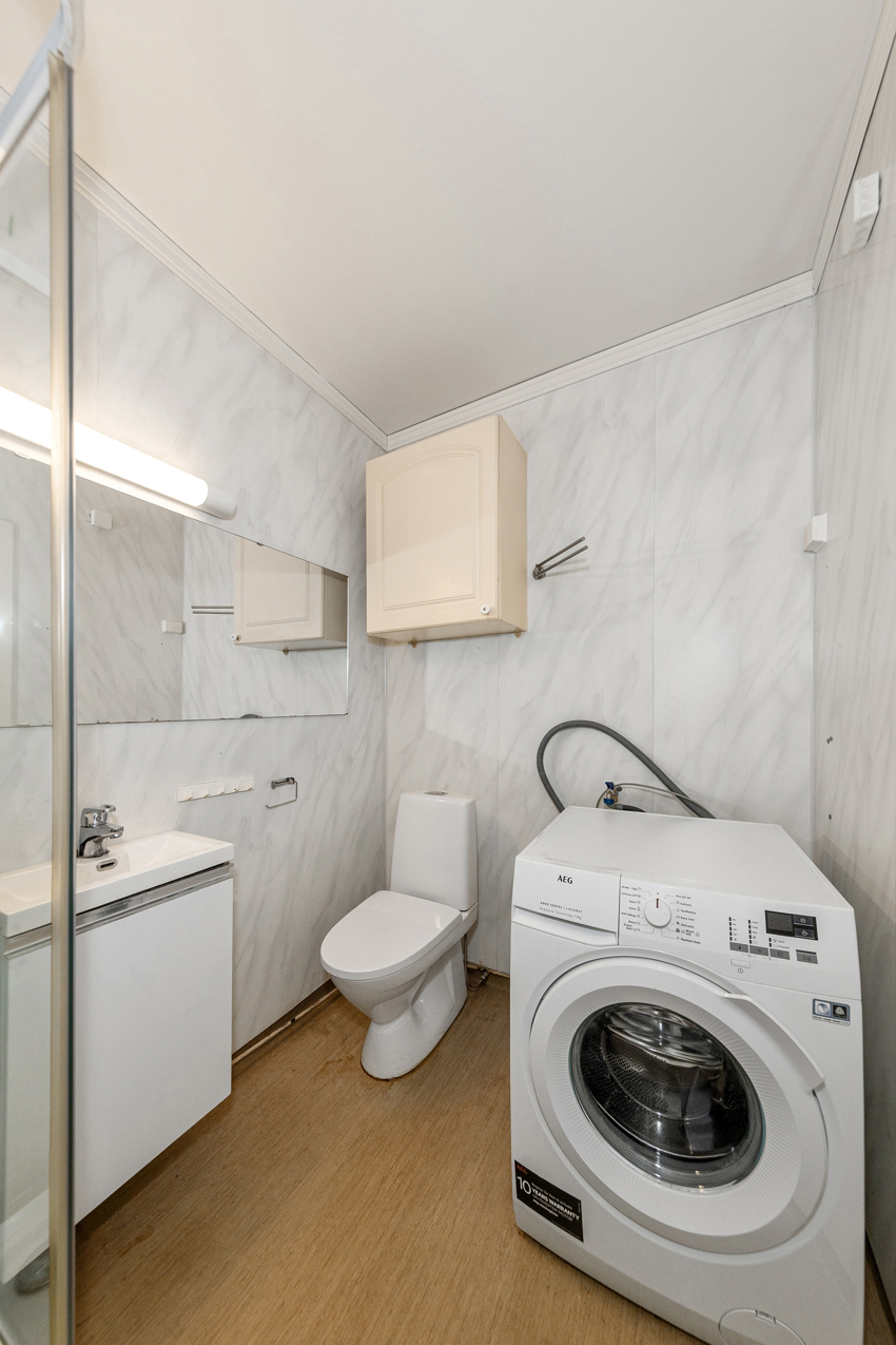 Et stort og godt baderom med dusjkabinett, innredning med nedfelt vask, underskap, toalett, spei og vaskemaskin. 