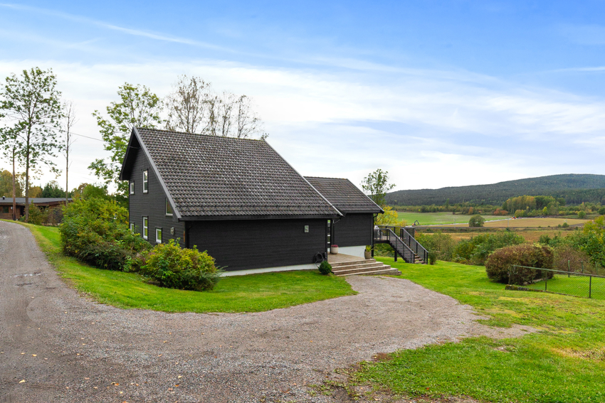 Huset ligger fint til over nærliggende landbruksarealer.
