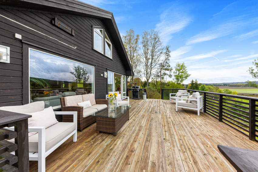 Romslig veranda med plass til flere sittegrupper. 