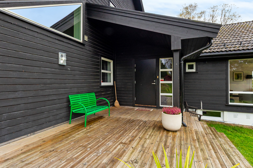 Delvis overbygd terrasse ved inngangsdør.