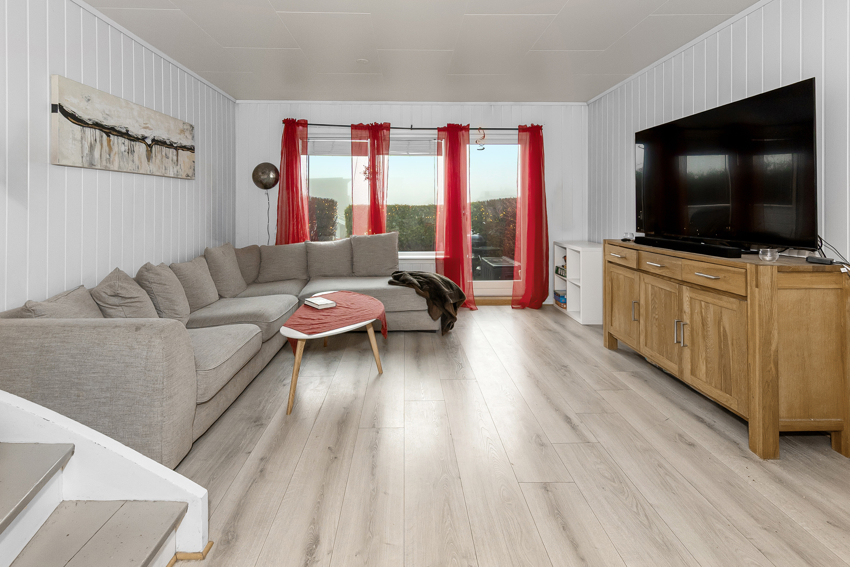 Lys og innbydende stue - verandadør ut til platting og liten hage.