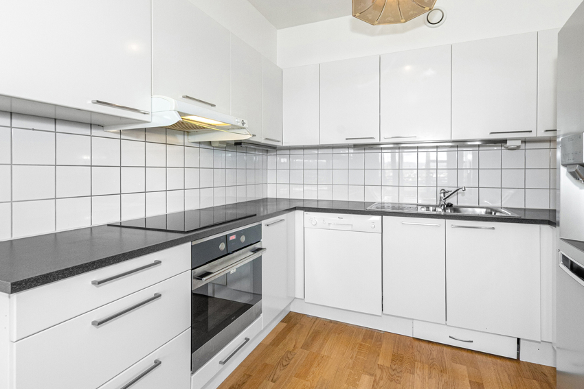 Kjøkkenet har laminat benkeplate, glatte fronter og integrerte hvitevarer