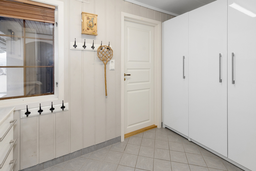 Vaskerom med dør inn fra gang. Flis og varmekabel på gulv.