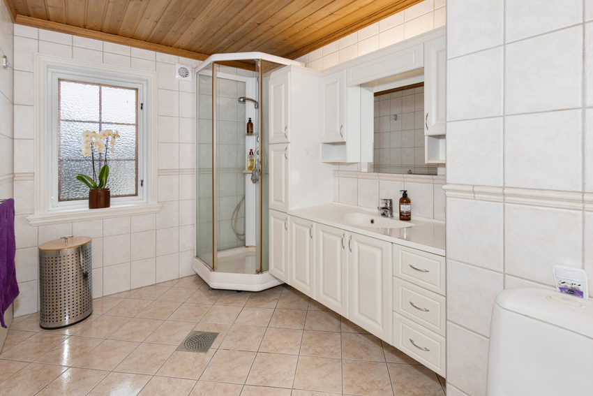 Romslig bad i 1. etasjen med flis og varmekabler på gulv.