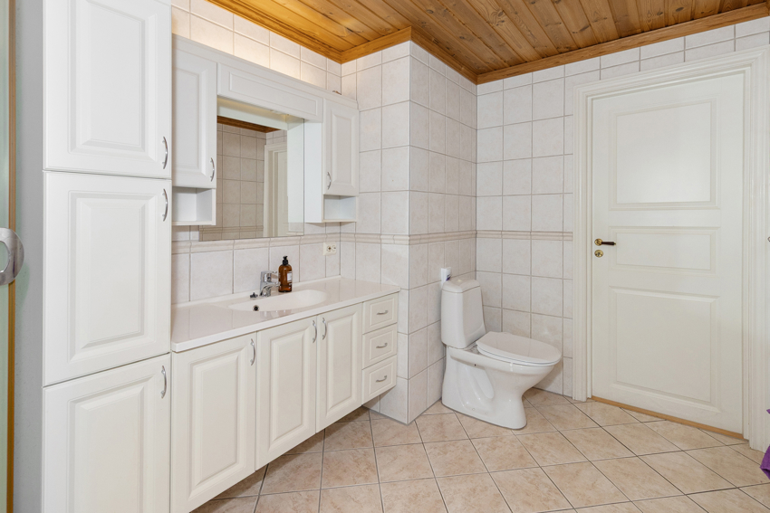  Det har god skap- og benkeplass med en stor baderomsinnredning i lys utførelse, samt dusjkabinett og toalett.