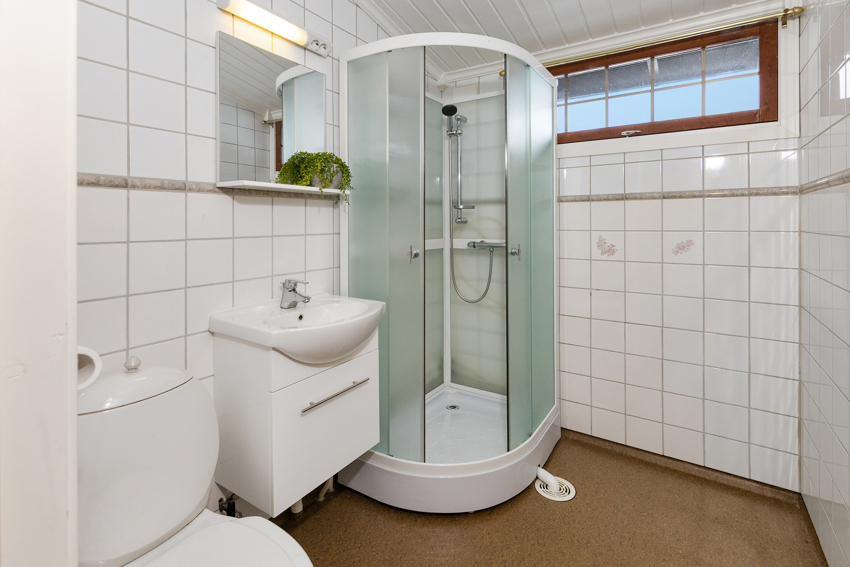 Bad i 2. etasje med dusjkabinett, toalett, servant med møbel, speil med skap.