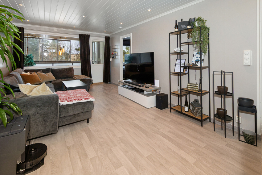 Lun og trivelig stue med utgang til innglasset balkong