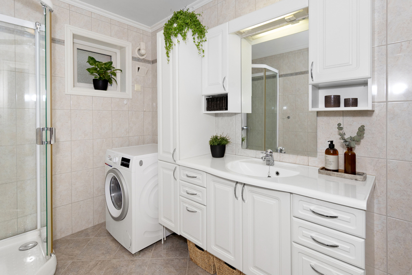 Romslig bad med servant og møbel. Plass til vaskemaskin og tørketrommel. 