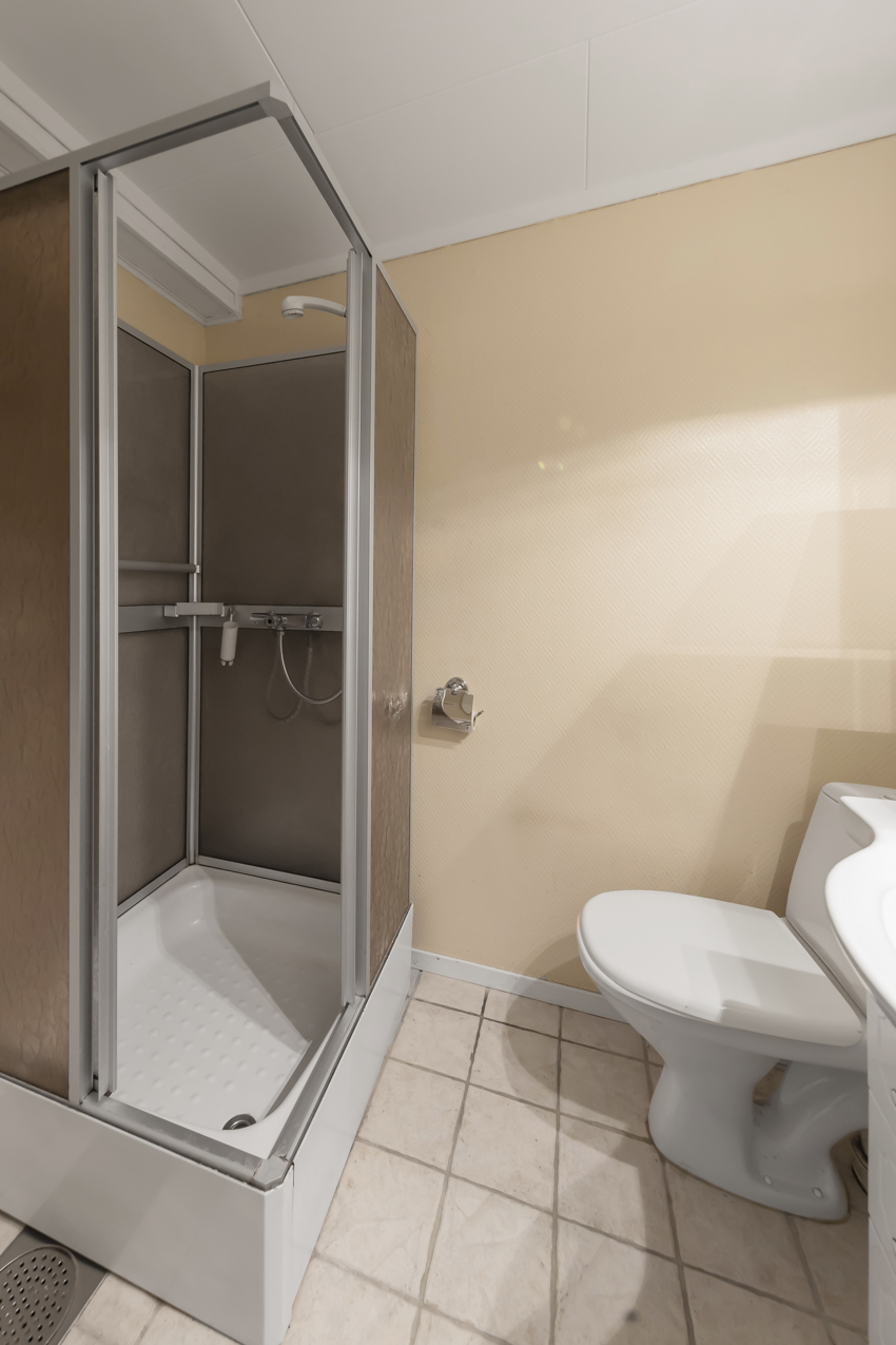 Badet har dusjkabinett, servantinnredning og wc.