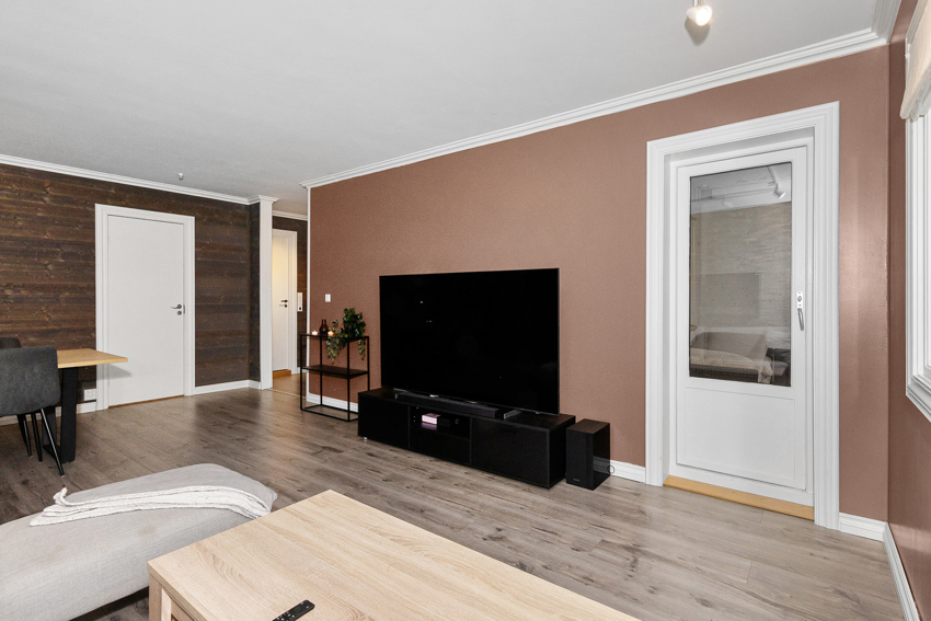 Stue med oppkobling av tråløst internett og TV plassert på vegg ved verandadør.