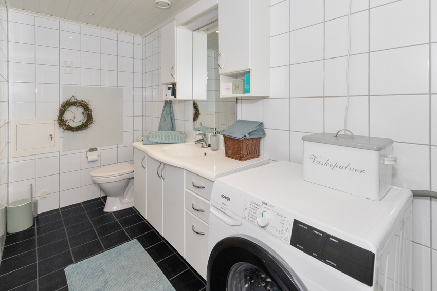 Servant i romslig innredning, toalett og opplegg for vaskemaskin/tørketrommel