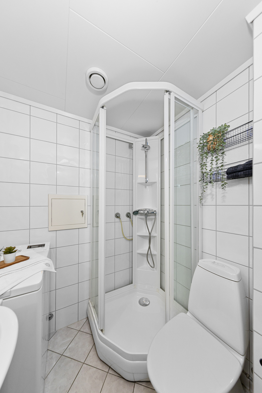 Dusjkabinett, servant med underskap og speil, toalett og opplegg for vaskemaskin