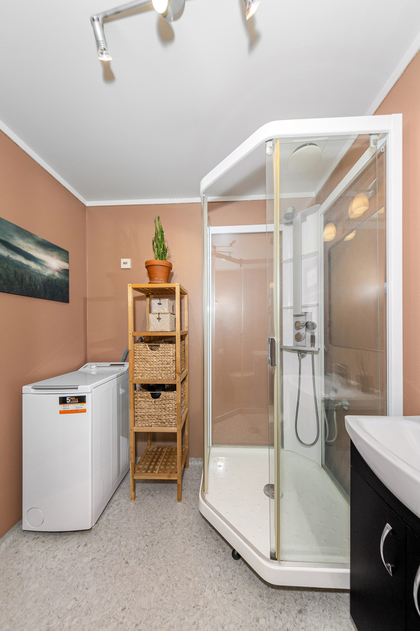 Dusjkabinett, servant med underskap og speil, toalett og opplegg for vaskemaskin