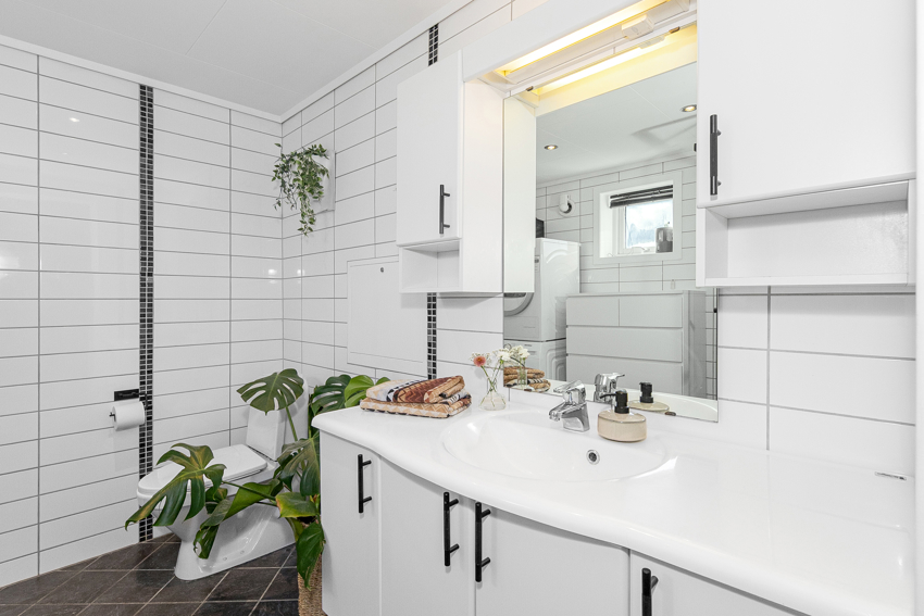 Servant i romslig innredning med overskap og speil