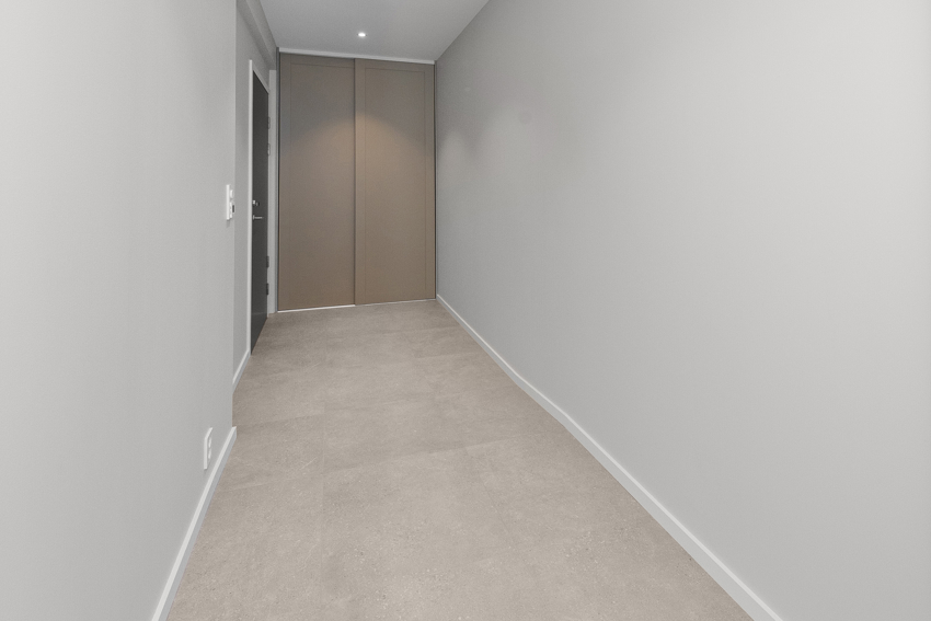 Romsling gang med garderobeskap. Flis med varmekabel på gulv. 