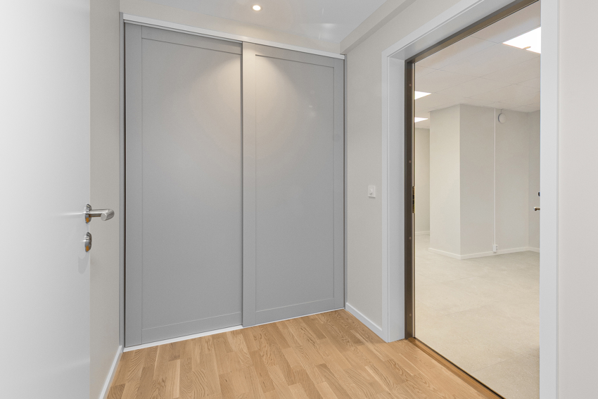 Romslig gang med skyvedørsgarderobe. 