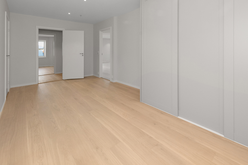 Meget romslig gang hvor det er satt inn en større skyvedørsgarderobe. Her er det god plass til ekstra møblering. 