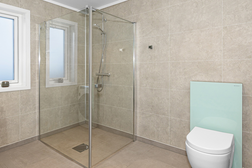 Badet i 1. etasje har dusjhjørne. Vegghengt toalett