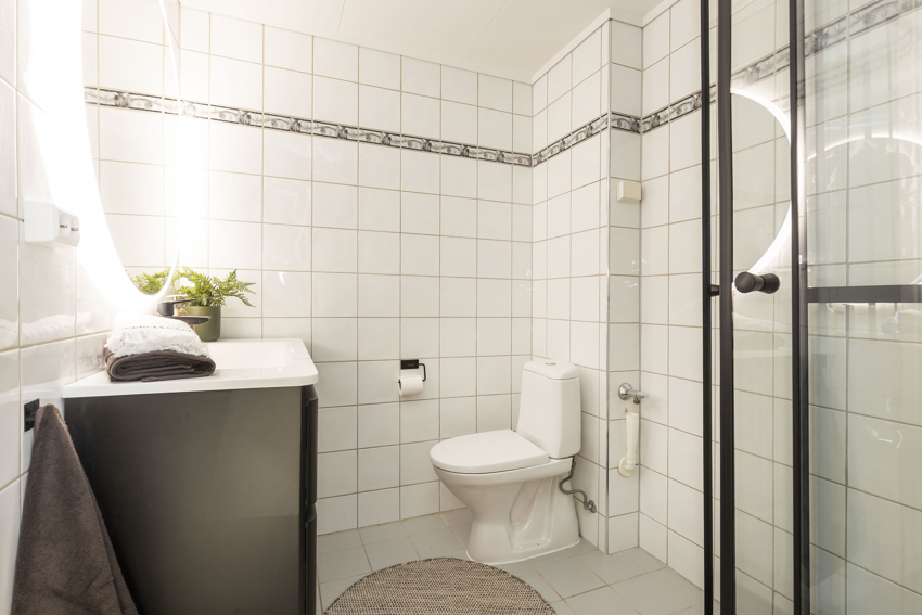 Pent baderom fra 2005, som har fått et løft i 2026 med ny baderomsinnredning med vask, speil og dusjkabinett.