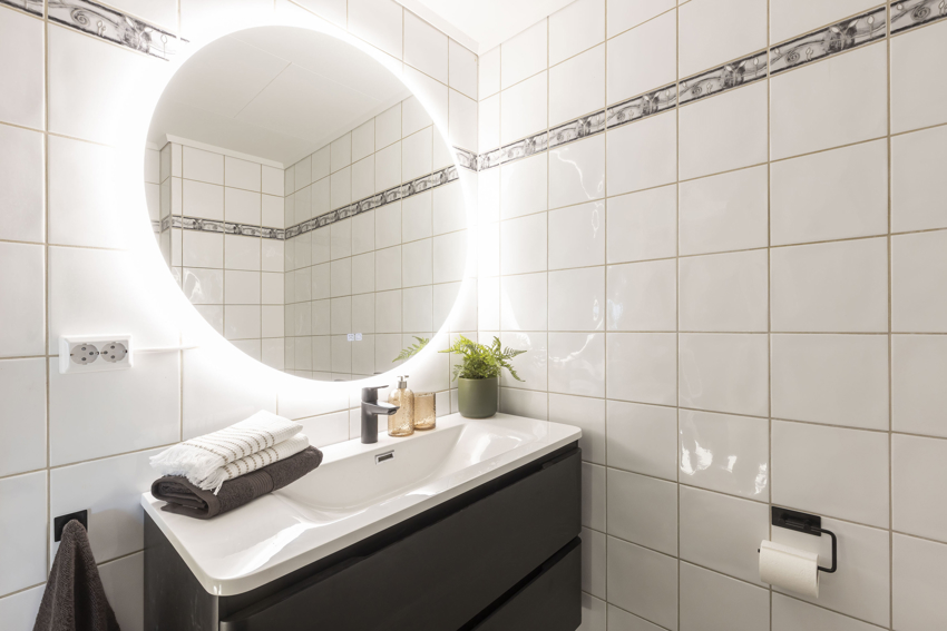 Badet har opplegg til vaskemaskin og er lyst og moderne.