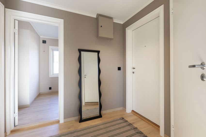 Gangen er malt i samme farge som leiligheten forøvrig, noe som gir en fin og helhetlig følelse. Det er plass til enkel stumtjener eller knaggrekk til jakker og plass til noe fottøy.